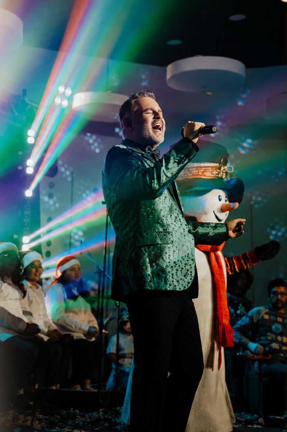 Solista cantando en el escenario de Jingle Night entre luces de colores